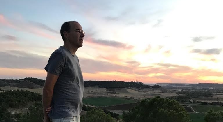 Ignacio Gallego de Lerma en lo alto de una montaña al atardecer, contemplando el paisaje con calma: una imagen que invita a habitar con criterio electromagnético nuestro lugar en el mundo, conectando con la naturaleza, el propio cuerpo y el entorno que cuidamos